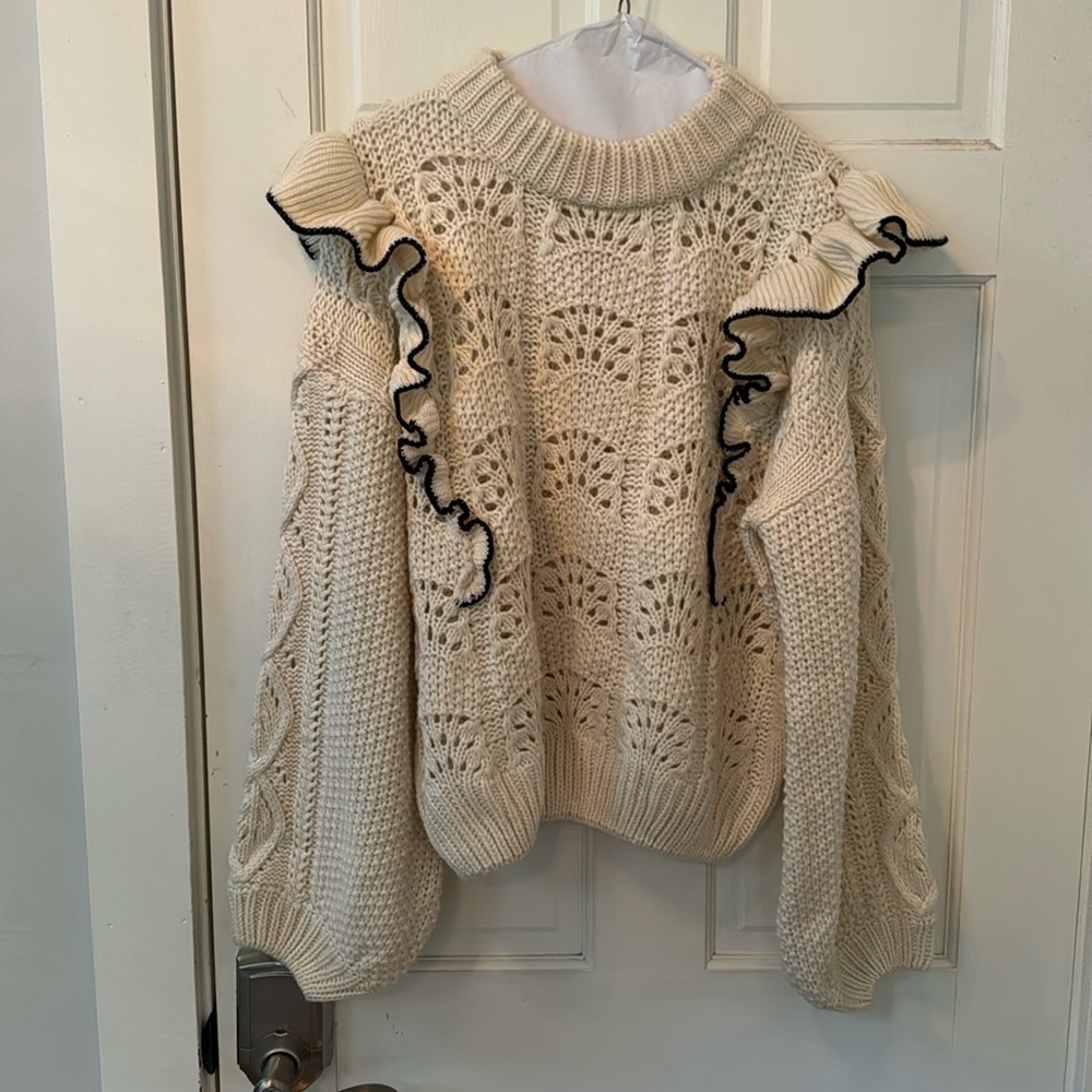 A fisherwoman’s sweater with black detailing and ruffle